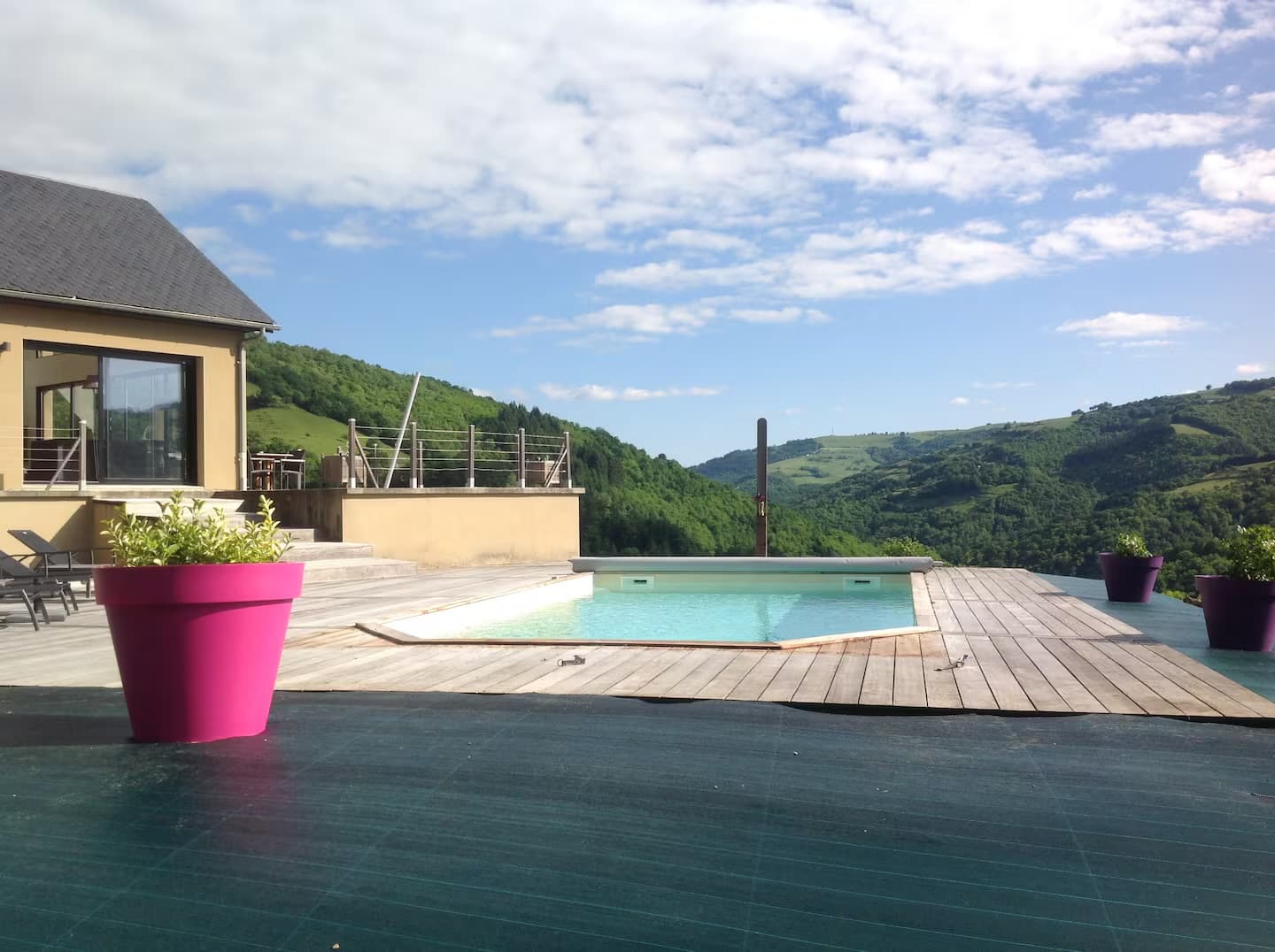 Piscine et large terrasse bois sous le ciel bleu